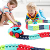 Enfants jouant avec un circuit voiture enfant looping coloré en forme de train sur un sol blanc.