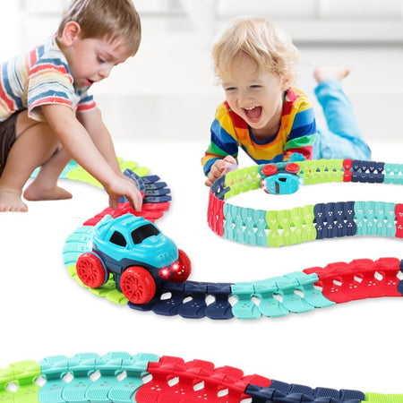 Enfants jouant avec un circuit voiture enfant looping coloré en forme de train sur un sol blanc.