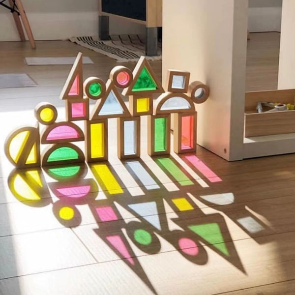 Blocs Lumiblocks alignés laissant passer la lumière et créant des reflets colorés au sol