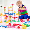 Enfant jouant avec un circuit à billes Billitrack en construisant un parcours coloré avec tubes et rampes