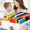 Parent et enfant jouant avec des dominos en bois colorés DominoBlox sur une table