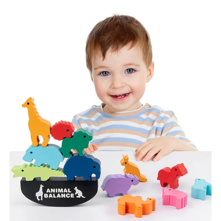 Petit garçon jouant avec jeu d’équilibre WobbleZoo en bois avec animaux colorés