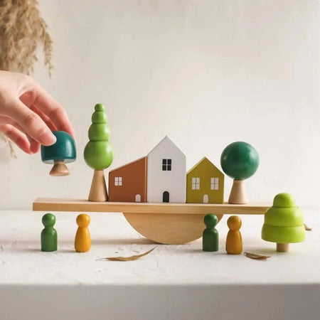 main positionnant une pièce sur jeu d’équilibre en bois Montessori HouseTilt EducaKid