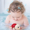 Bébé jouant avec une tortue nageuse dans le bain pour stimuler l’éveil et la curiosité