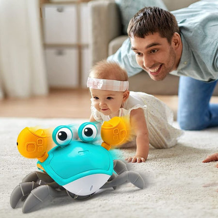 Bébé jouant avec jouet crabe interactif qui rampe avec musique et lumière pour stimuler l’éveil