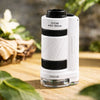 Microscope VisionKid avec zoom réglable 60x à 180x posé sur une surface naturelle en bois