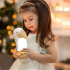 Enfant tenant la veilleuse toucan LumaTouco portable dans une ambiance douce et rassurante